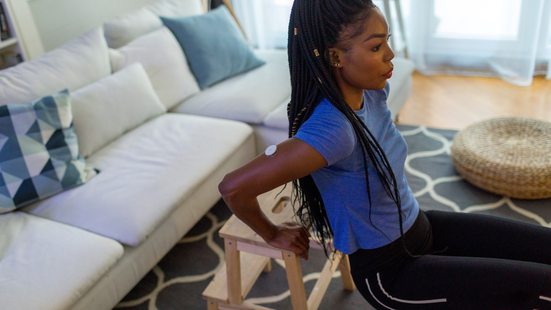 A young woman exercises by doing crunches in her living room.